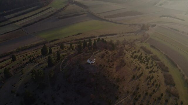 Aerial view of tranquil countryside with church, hill, and cross, Burladingen, Baden-Wurttemberg, Germany.