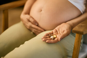 Pregnant woman taking all needy supplements for her health.