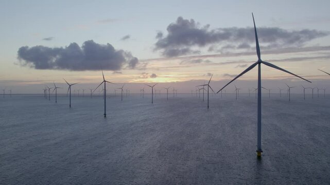 Aerial view of offshore windpark with wind turbines in sunrise, Afsluitdijk, Netherlands.