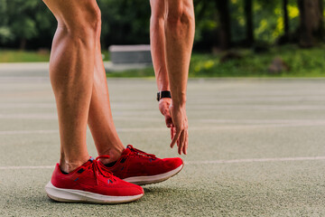 Close-up shot of a runner touching toes to warm up before training