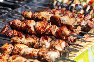 Meat is fried on skewers over coals on a grill