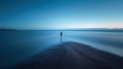 Melancholy induced solitary figure on empty beach with long exposure seascape, with copy scape