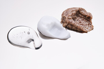 Facial serum, scrub and cream on a stainless steel surface. Texture.