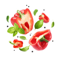 Cut bell peppers, basil and allspice in air on white background