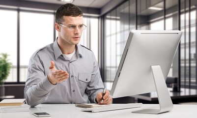 Young happy businessman at work in office