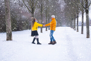 happy mature man and woman spinning in alley, joyful couple enjoying leisurely stroll through picturesque park, surrounded serene snow-covered landscapes, Winter Romance, Seasonal Happiness