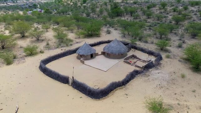 desert life in Tharparkar village, traditional desert houses and wooden huts, Amidst the world's largest desert, thar Desert landscape life aerial view.
