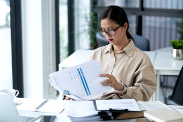 senior businesswoman sitting and seriously reading business documents