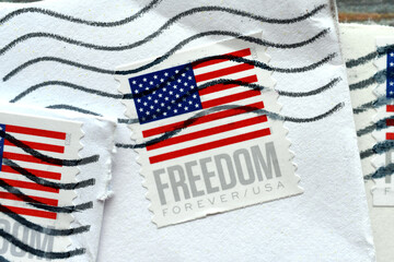 Closeup of US postage Forever stamps with American flag with postmark