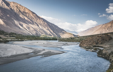 Obraz premium The Panj River flows between Afghanistan and Tajikistan along the Pamir Highway road in the Tien Shan mountains