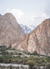 Rocky mountain a massif of red powerful rocks with snow and glaciers at sunset in the evening in the Tien Shan mountains in the Pamirs