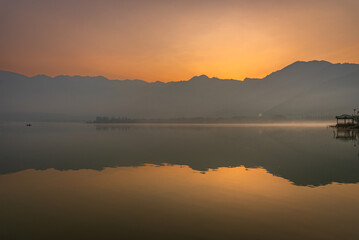 Panoramic landscape of Dal Lake nestled in Himalayas mountain range during sunrise on autumn morning from lake view point at Srinagar, Jammu and Kashmir, India.