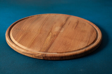 pizza cutting board at table in front, with dark background