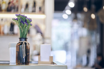 Focus on the vase with dried flowers on the table. The unfocused interior of the restaurant. There is a place to copy. An image of a coffee shop with a side to use as a background. High quality photo