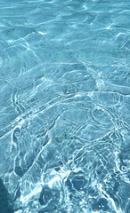 Aqua  liquid colored clear water surface texture with splashes bubbles with copy space. Water waves in sunlight background.
