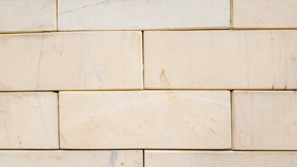 Close-up of smooth beige bricks aligned in a wall, representing construction and home improvement concepts