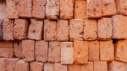 Fototapeta premium A neatly stacked pile of red clay bricks, symbolizing construction and urban development