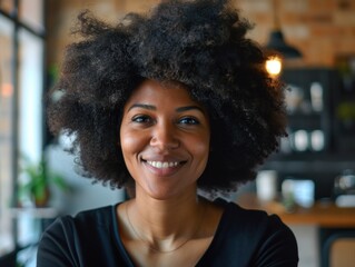 Obraz premium A black woman with an afro hairstyle smiling directly at the camera, suitable for use in various contexts such as advertising, editorial, and personal projects