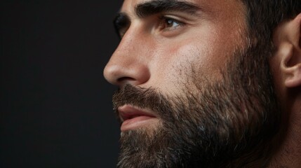 Obraz premium A close-up portrait of a man with a beard looking away from the camera.