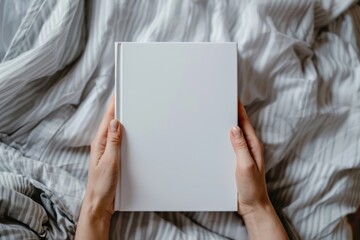 Naklejka premium A caucasian person holding an empty white book cover for a potential copy space photograph
