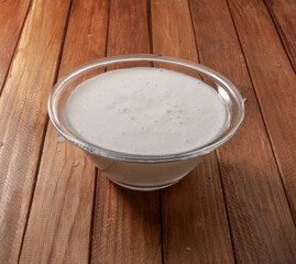 Salsa de trufa en recipiente de cristal sobre mesa de madera. Truffle sauce in glass container on wooden table.