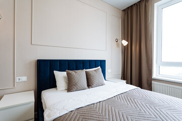 The bedroom is furnished with a bed, nightstand, lamp, and window, creating a cozy and comfortable ambiance in the room. The decor includes furnishings like textiles, wood floors, and fixtures