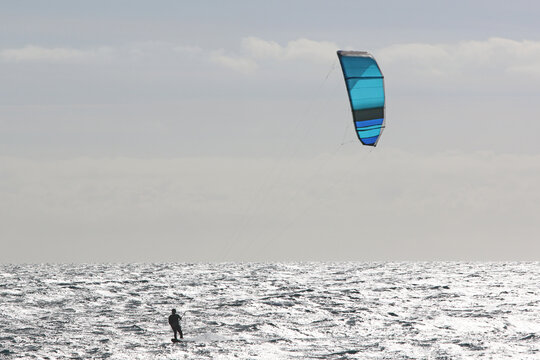 Kitesurfer riding his board in waves	
