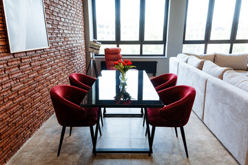 A living room with a table and chairs and a brick wall