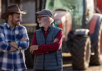 Two farmers in front of tractor on cattle farm