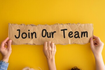 Inviting Collaboration: Two Hands Holding 'Join Our Team' Sign on Vibrant Yellow Background
