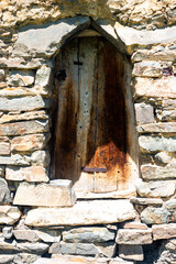 Closed old wooden shutters in a stone house high in the mountains