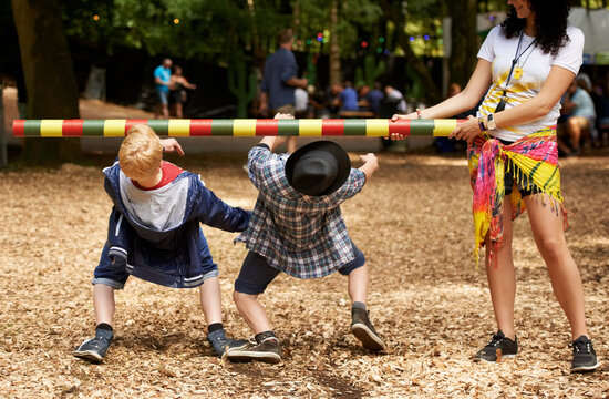 How low can you go. Shot of two kids doing the limbo at an outdoor festival.
