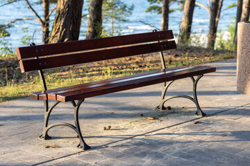 A comfortable wooden bench on an alley by the sea.