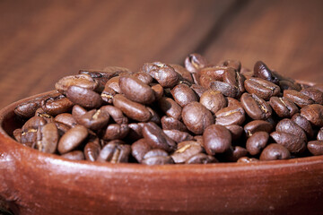 Freshly roasted coffee beans with lots of aroma and flavor on a rustic wooden table