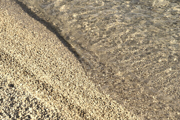 Sea water and small pebbles beach in sepia color tone from above