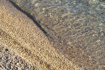 Sea water and small pebbles beach from above