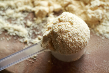 Whey protein powder in a measuring spoon