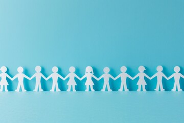 A group of paper people holding hands. The concept is one of teamwork, society, and business.