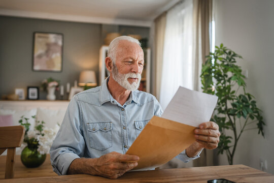 Senior man open and read a letter document from envelope good news