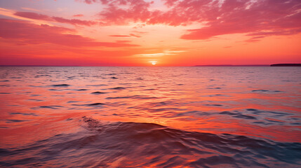 Obraz premium Vibrant Orange and Pink Sunset Reflecting on Calm Ocean Waves