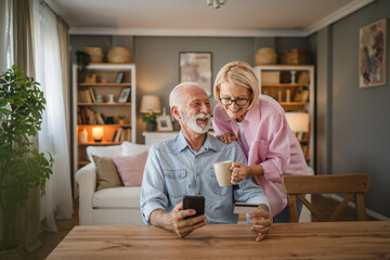 Senior couple buy online whit credit card on mobile phone at home