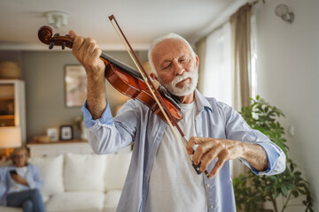 senior caucasian man learn to play violin practice at home