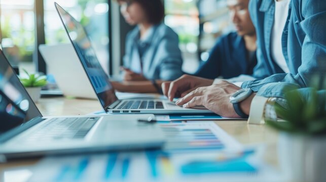 Business Professionals Analyzing Financial Forecasts in Open Office, Using Laptops and Documents - Powered by Adobe