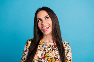 Photo of tricky positive woman wear print dress stick out looking empty space isolated blue color...