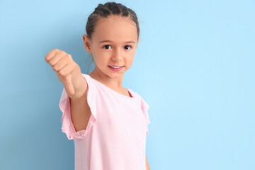 Little girl showing dislike on blue background