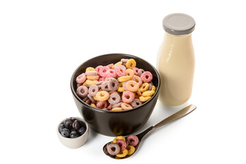 Bowl with colorful sweet cereal rings, bottle of milk and blueberries on white background