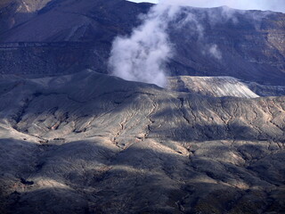 active volcano in Aso, Kumamoto, Japan, with volcanic fumes from the crater. Desolate landscape...