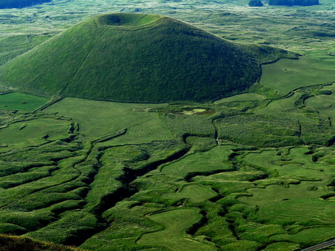 Komezuka, green volcanic cone in Aso caldera in Kyushu, Japan, surrounded by green grasslands