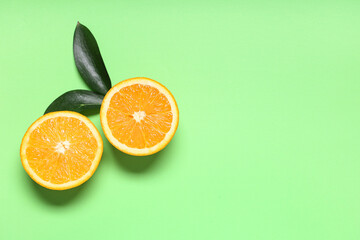 Composition with ripe tasty oranges on green background