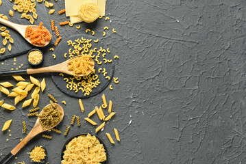 Composition with different tasty uncooked pasta on dark background